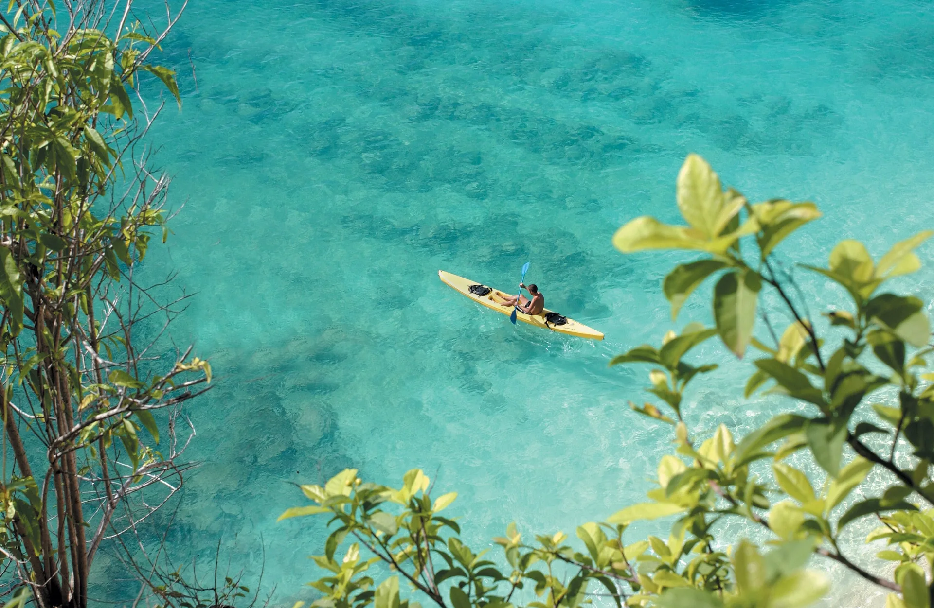 Kayaker paddling through clear turquoise water near La Samanna, St Martin.