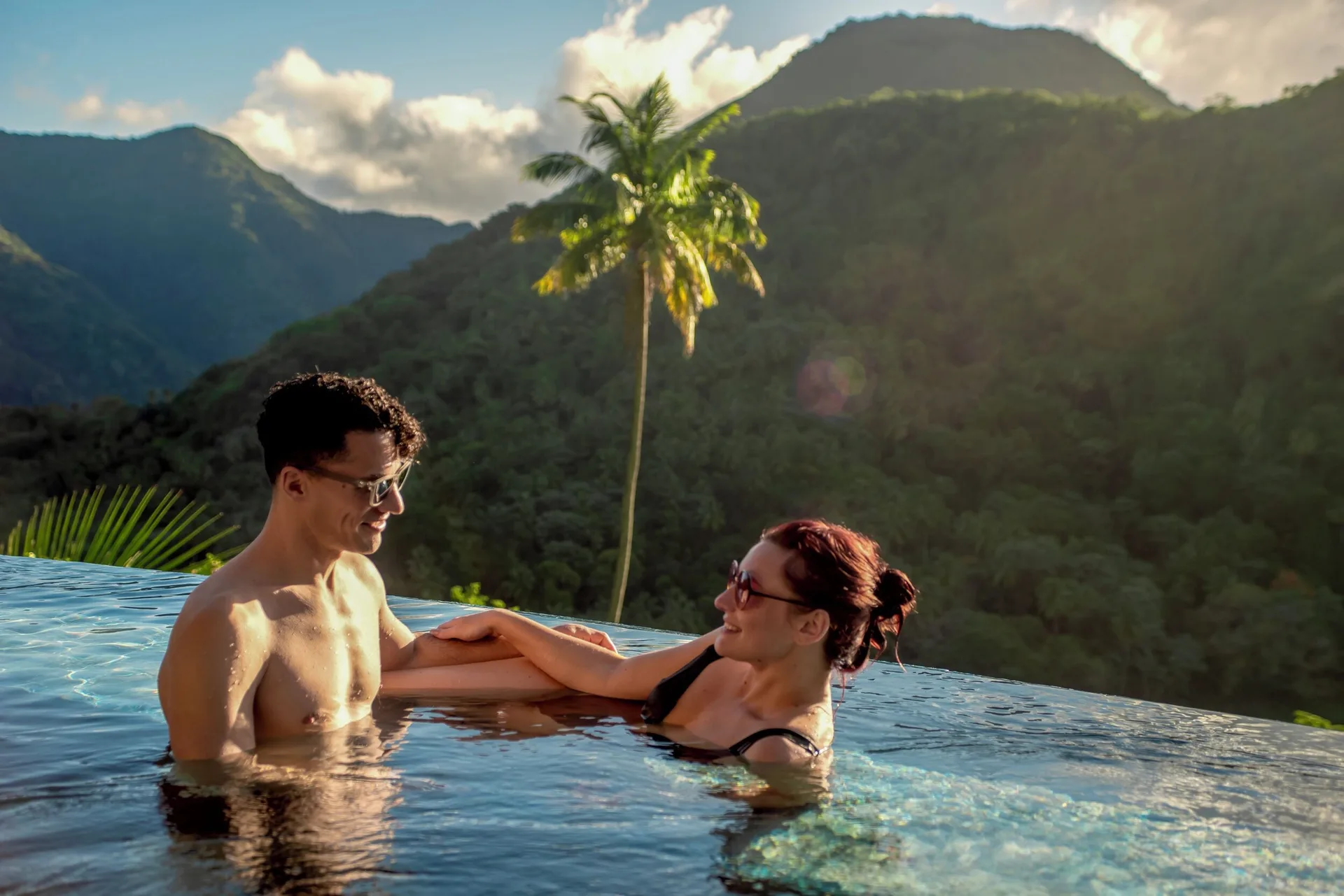 Couple relaxing in an infinity pool with a mountain valley view at Ladera Resort.