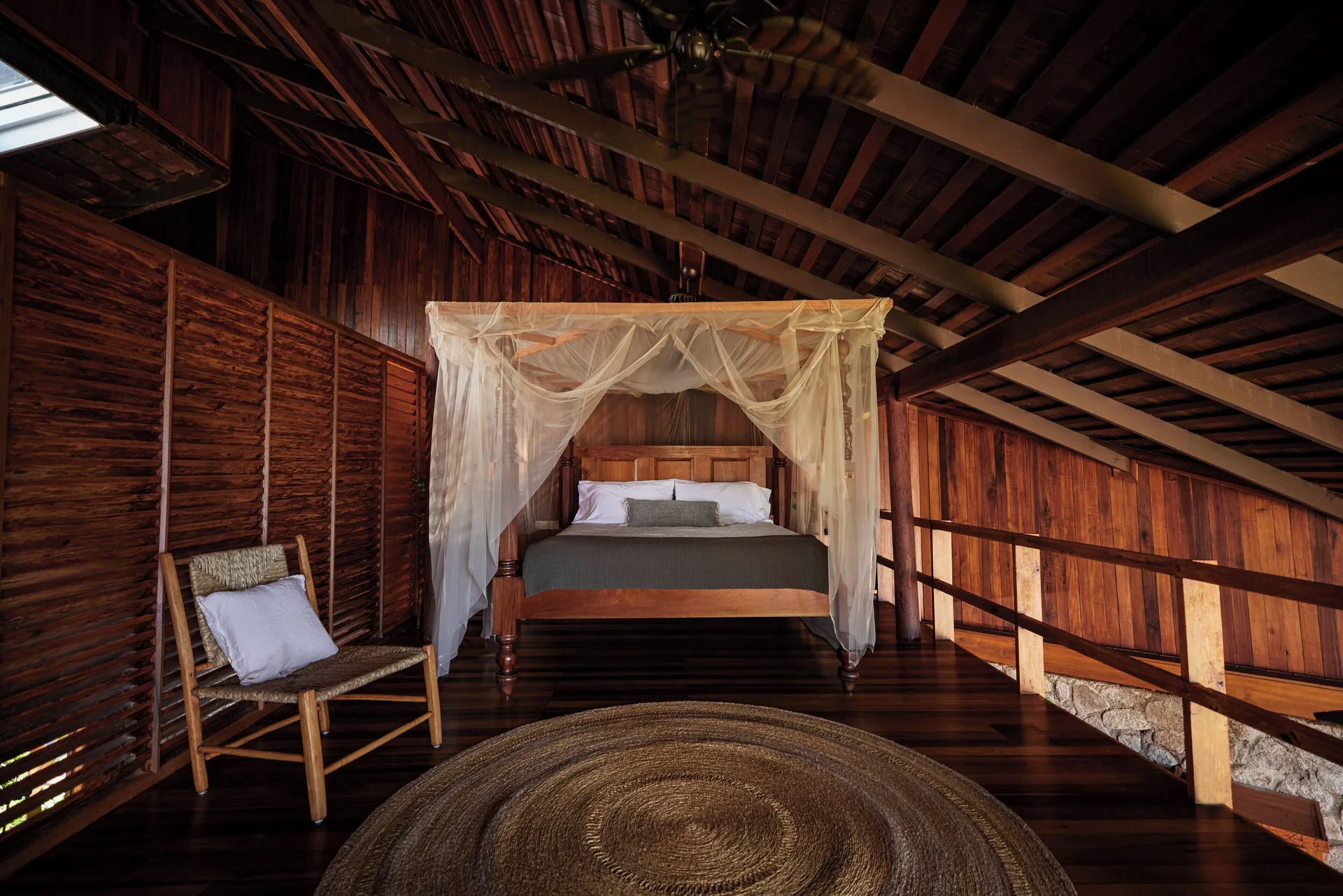 Heritage Suite canopy bed under a timber roof at Ladera Resort.