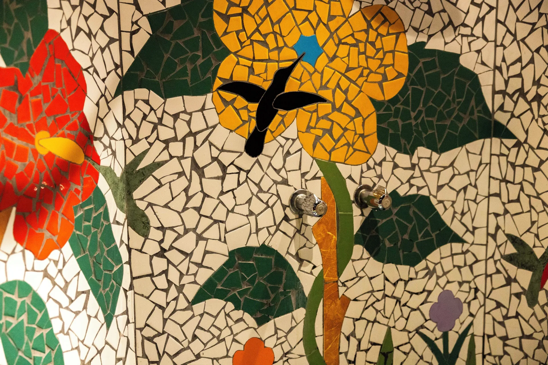 Rainbow Suite mosaic shower wall with flower and hummingbird design at Ladera Resort.