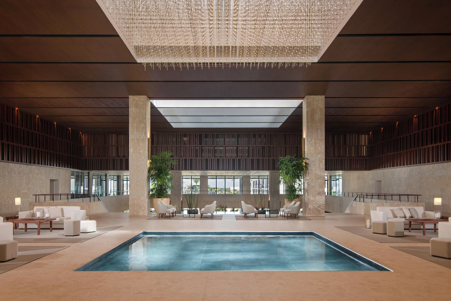 Lobby pool with lounge seating and chandelier at Live Aqua Punta Cana.