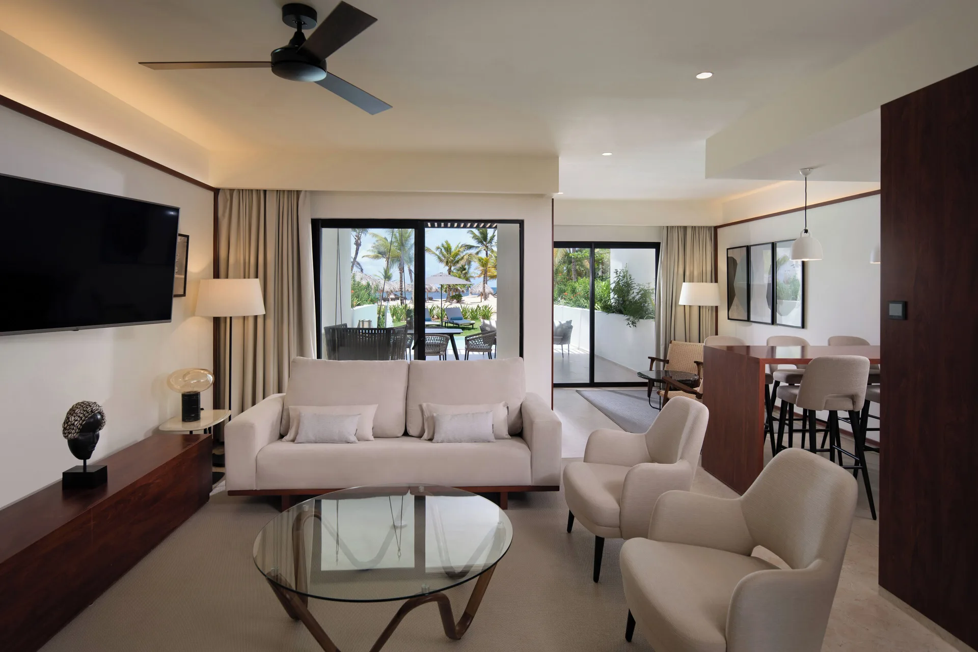 Suite living room with sofa, dining area, and terrace view at Live Aqua Punta Cana.