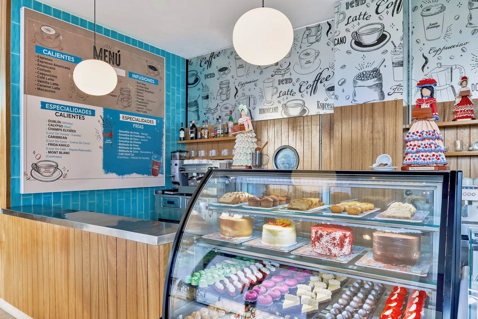 Coffee shop display case with cakes, pastries, and a menu at Live Aqua Punta Cana.