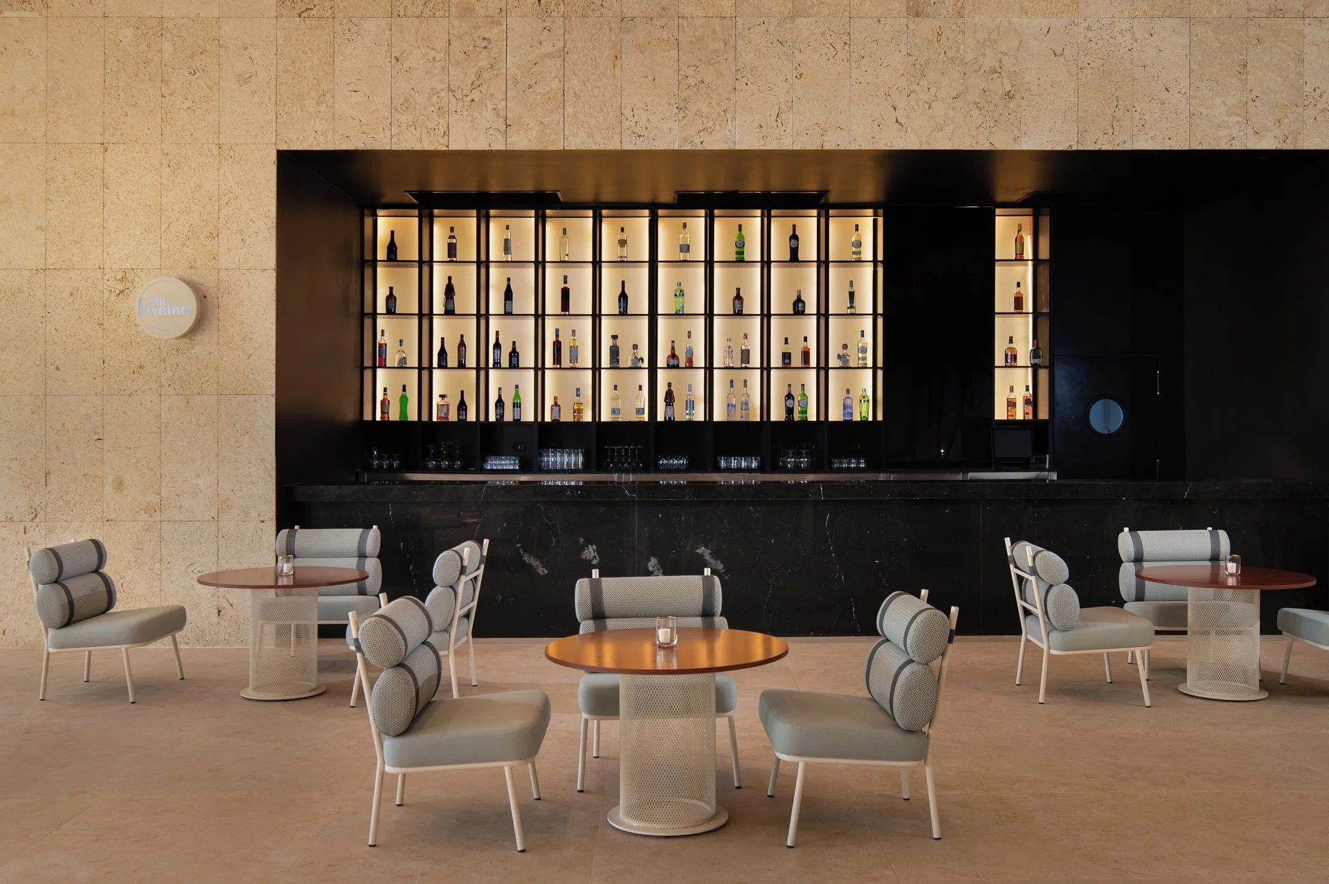 Illuminated lobby bar shelves with lounge seating at Live Aqua Punta Cana.