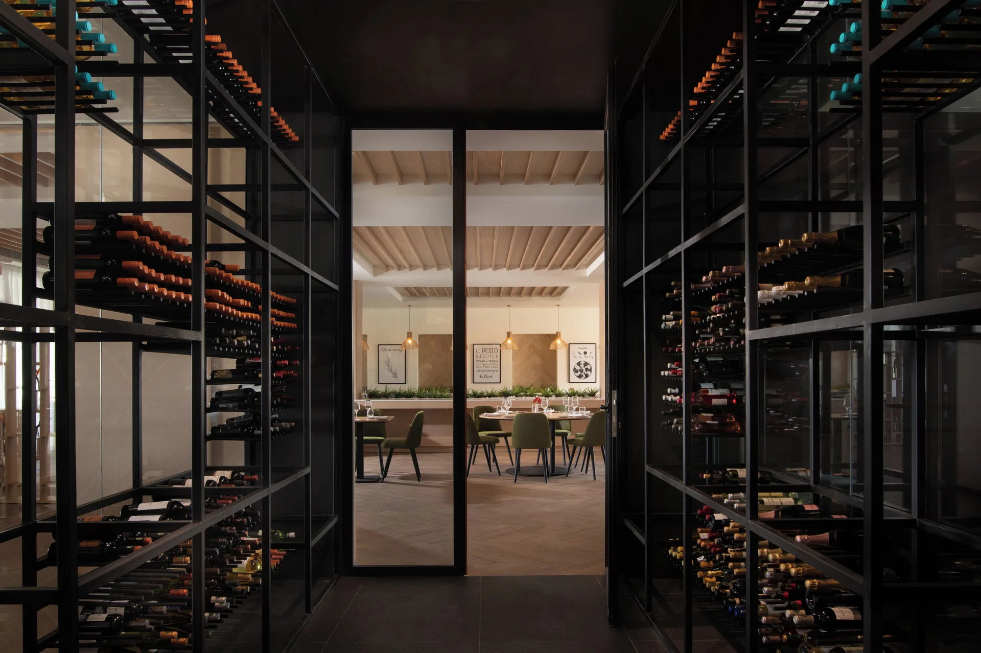 Wine display corridor with bottle racks leading to a dining room at Live Aqua Punta Cana.