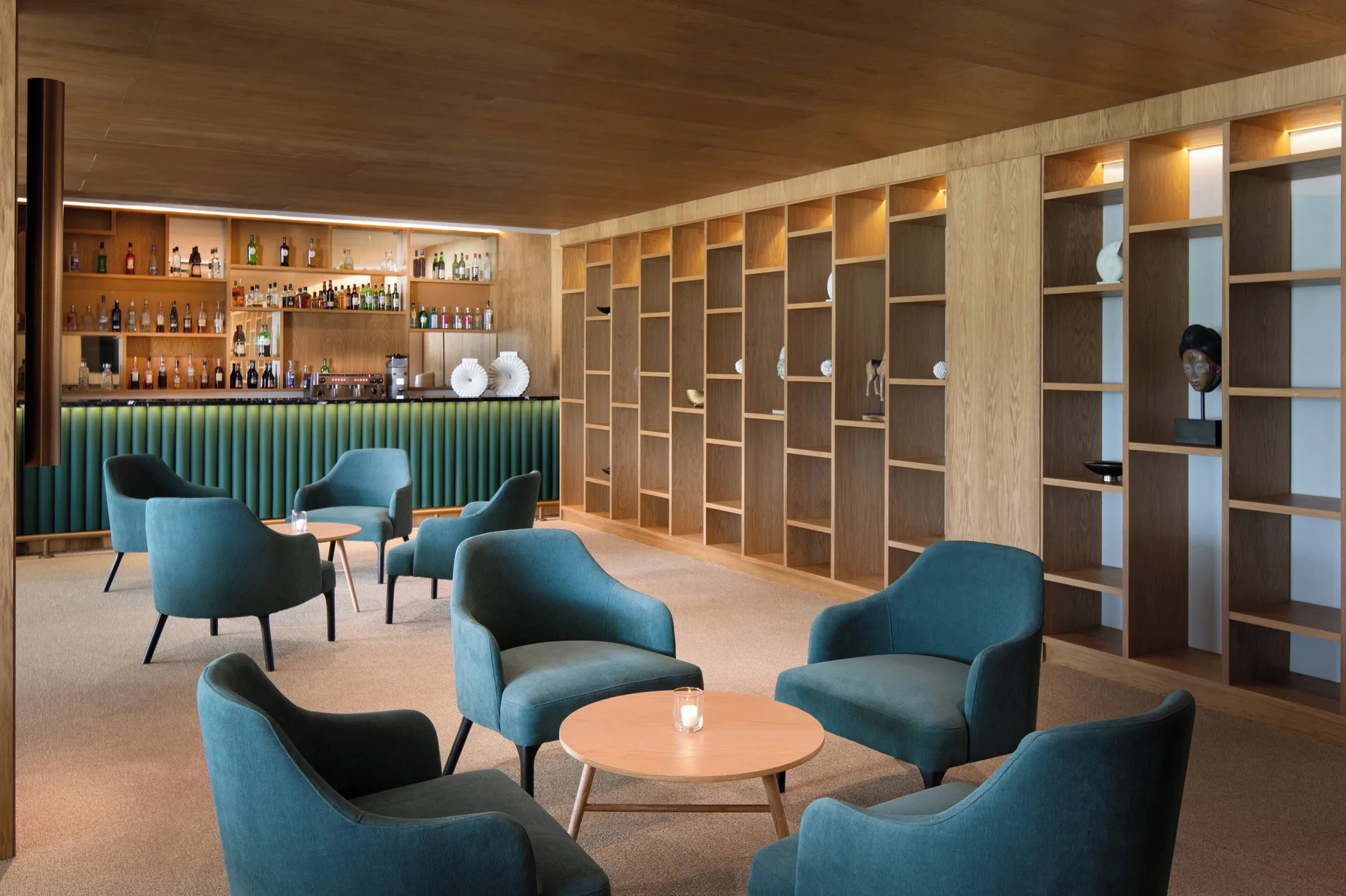 Indoor lounge with bar and teal chairs at Live Aqua Punta Cana.