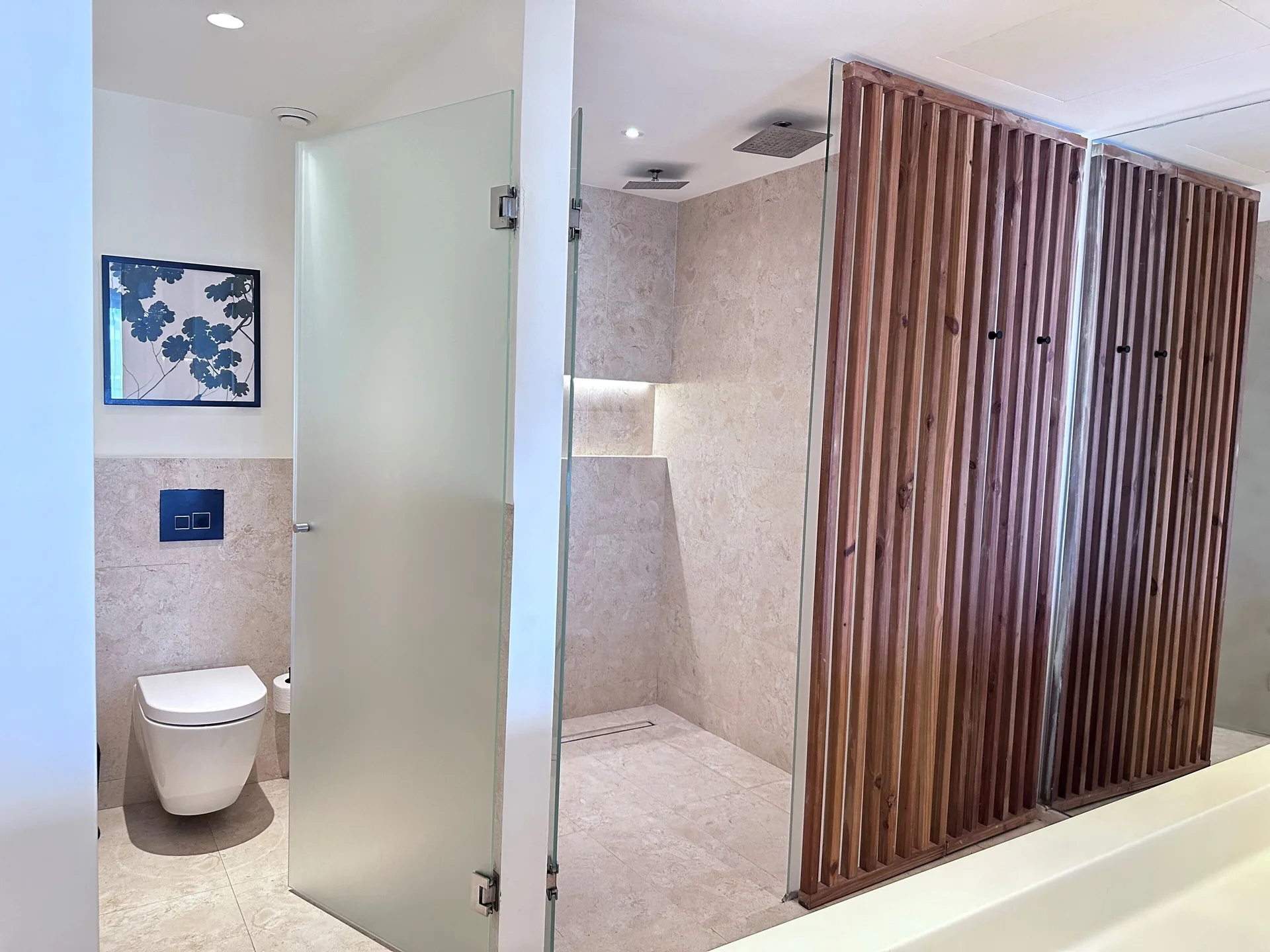 Bathroom with glass shower and toilet area in a Junior Suite Deluxe Garden View at Live Aqua Punta Cana.