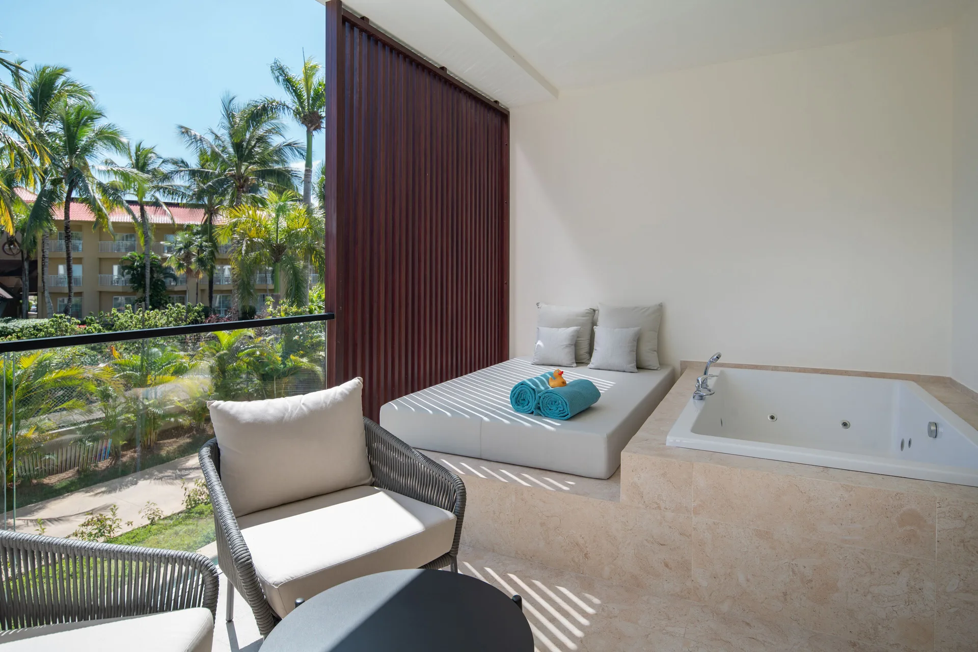 Terrace with whirlpool tub and loungers in a Junior Suite Deluxe Garden View at Live Aqua Punta Cana.