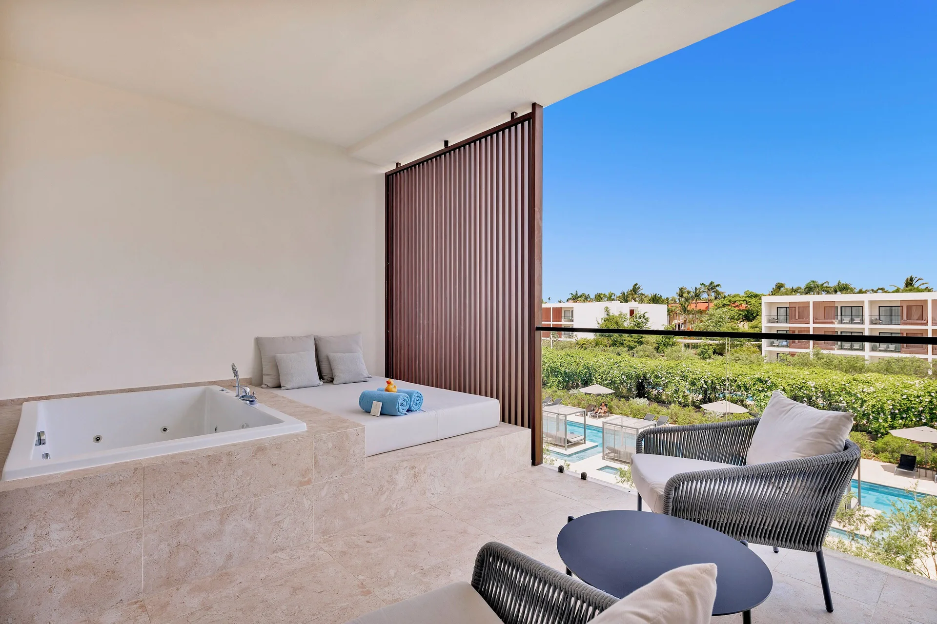 Pool-view terrace with whirlpool tub and daybed at Live Aqua Punta Cana.