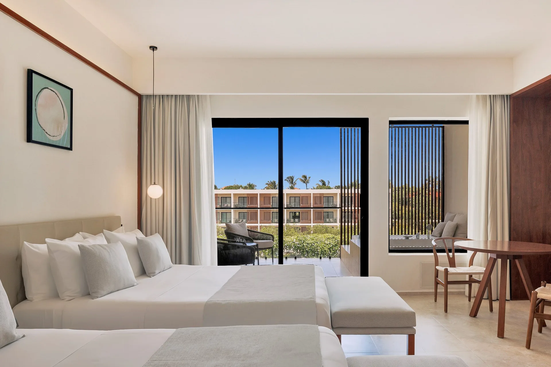 Junior Suite Deluxe Pool View with two beds and balcony doors at Live Aqua Punta Cana.