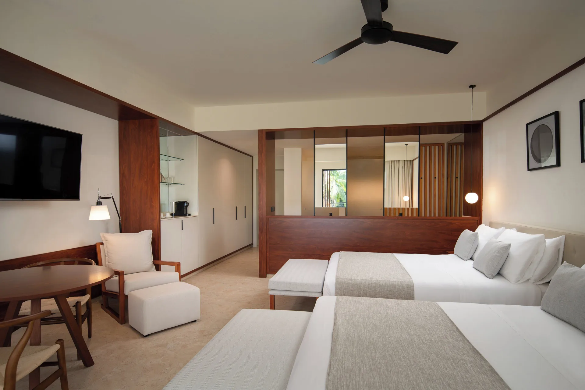 Junior Suite Deluxe Pool View with two beds and dining table at Live Aqua Punta Cana.