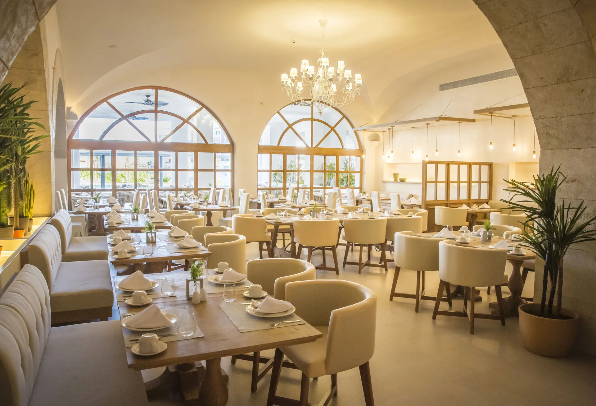 Bright restaurant dining room with arched windows at Majestic Elegance Costa Mujeres.