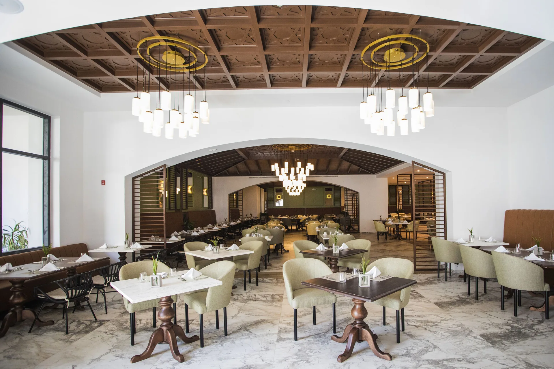 Elegant dining room with chandeliers and arched openings at Majestic Elegance Costa Mujeres.