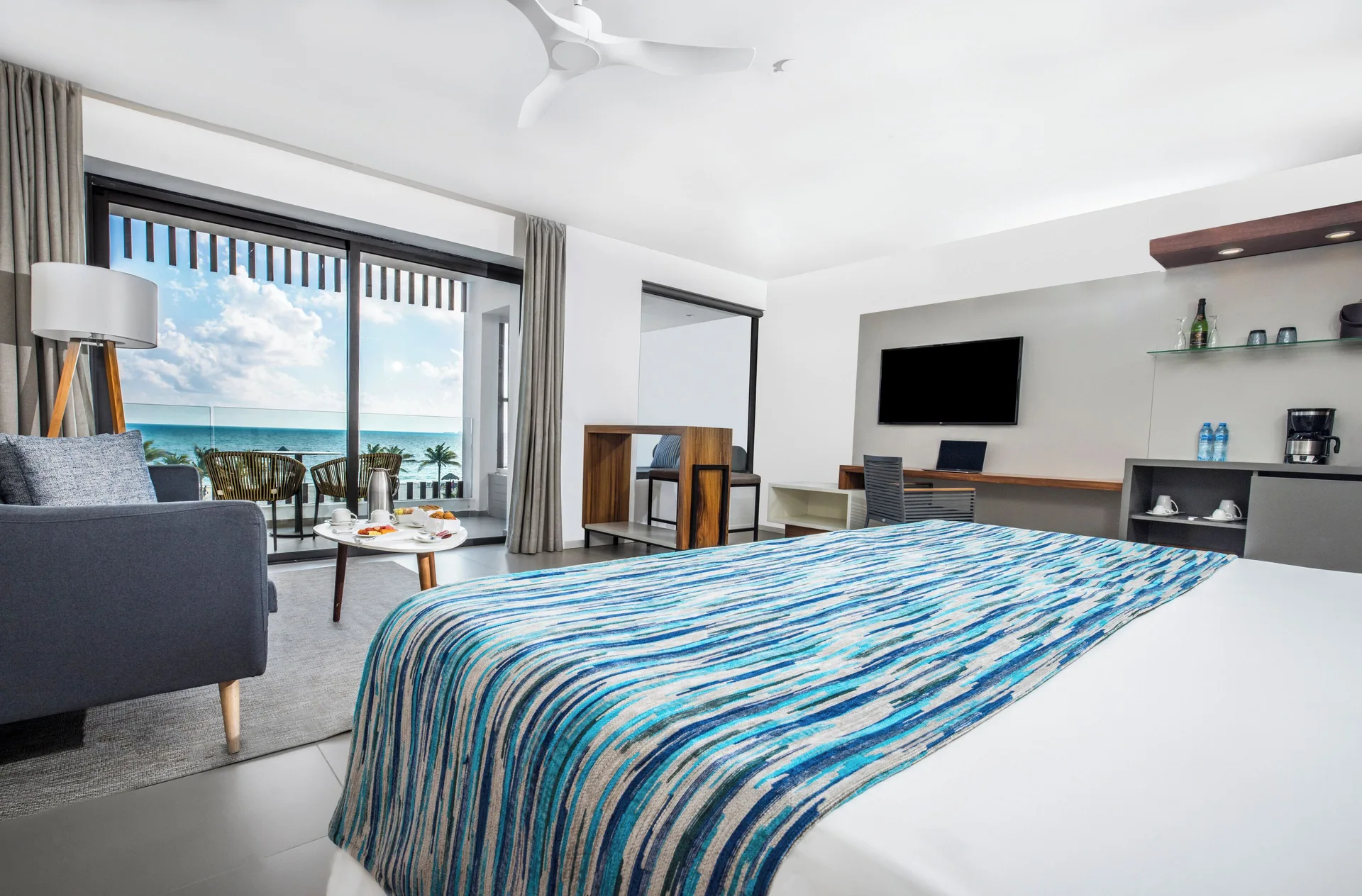 Oceanfront junior suite with king bed and balcony at Majestic Elegance Costa Mujeres.