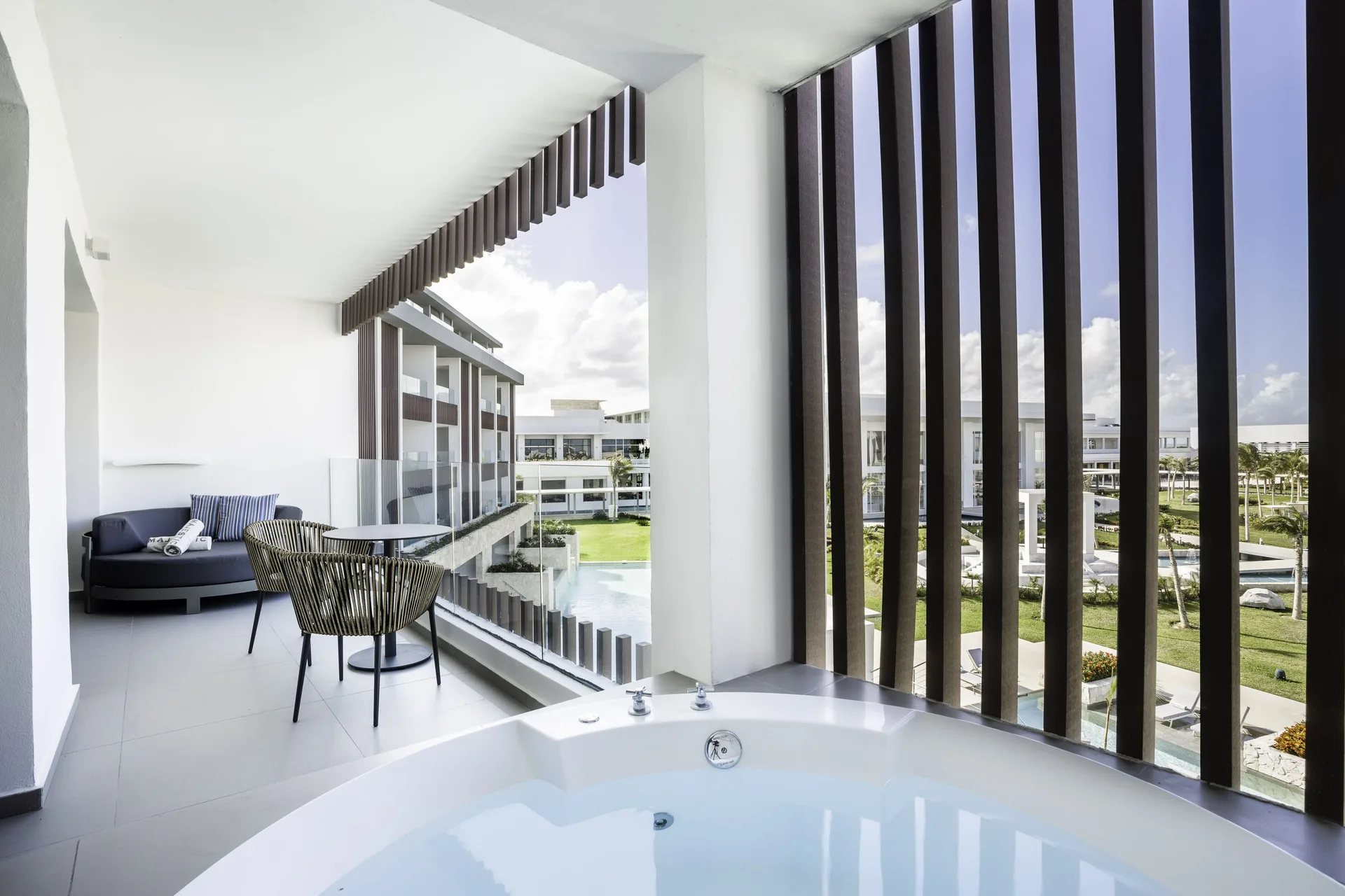 Outdoor Jacuzzi on the suite balcony at Majestic Elegance Costa Mujeres overlooking the resort grounds.