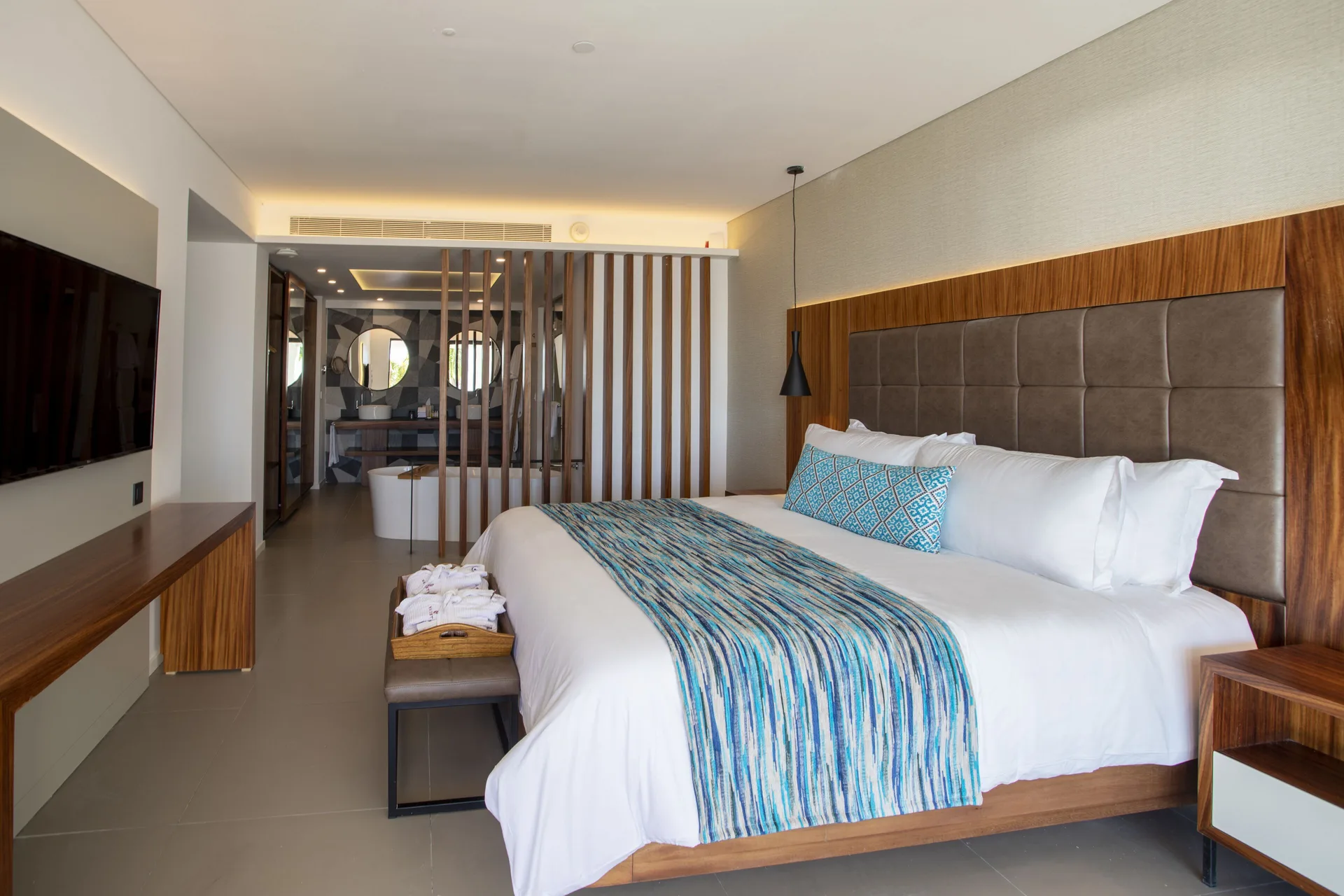 Elegance Club One Bedroom Suite king bed at Majestic Elegance Costa Mujeres with bath area beyond.
