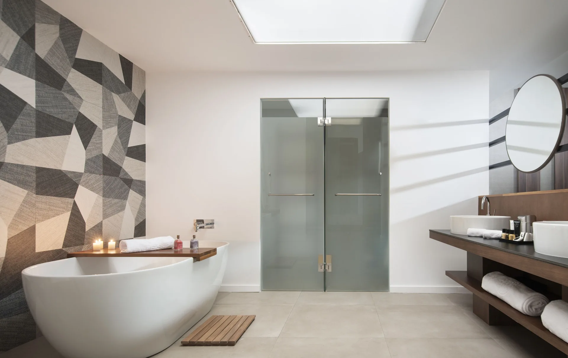 Junior Suite bathroom at Majestic Elegance Costa Mujeres with tub, frosted shower doors, and double vanity.