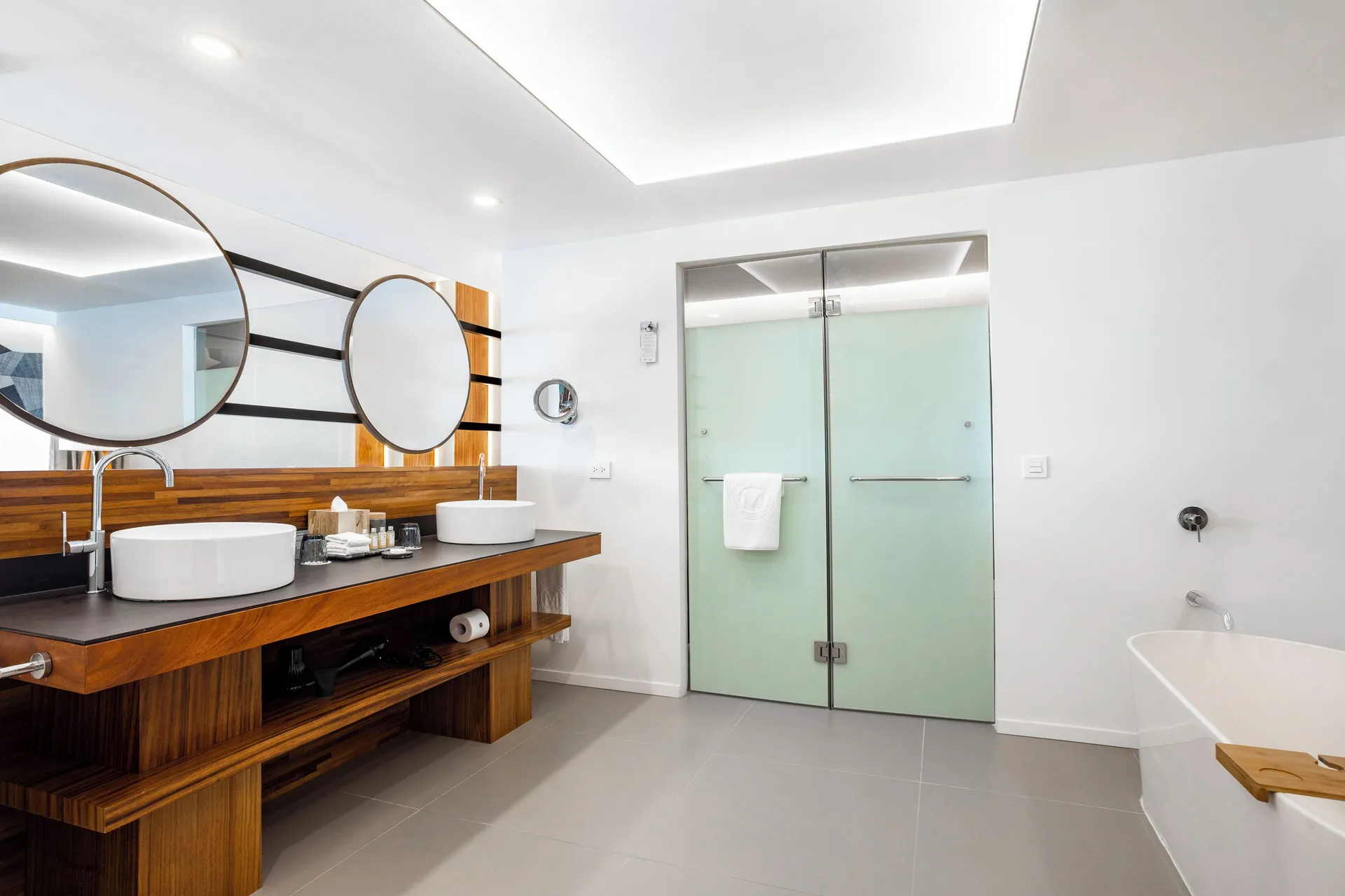 Junior Suite bathroom vanity at Majestic Elegance Costa Mujeres with twin sinks, mirrors, shower, and tub.