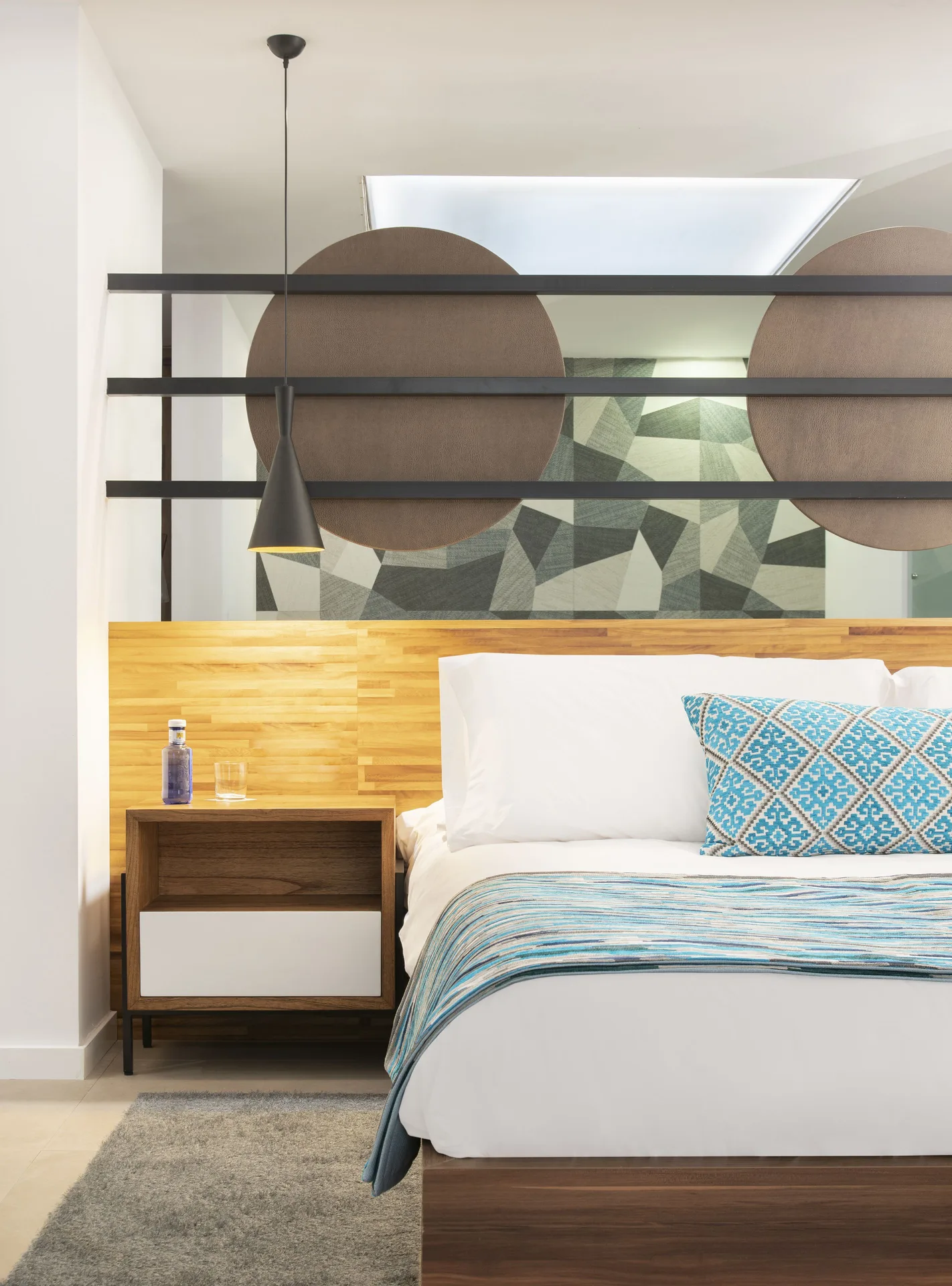 Junior Suite king bed detail at Majestic Elegance Costa Mujeres with bedside table and pendant light.