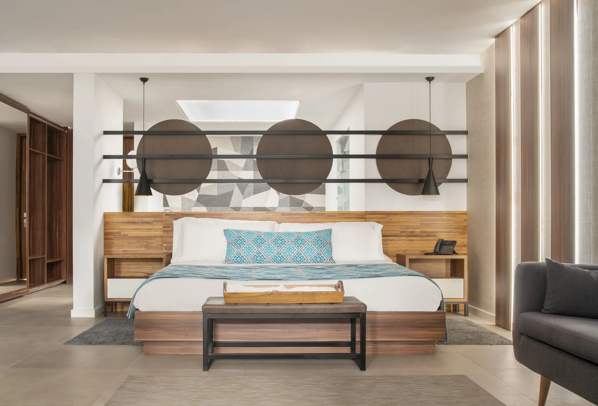 Junior Suite king bed at Majestic Elegance Costa Mujeres with wood headboard and patterned wall art.