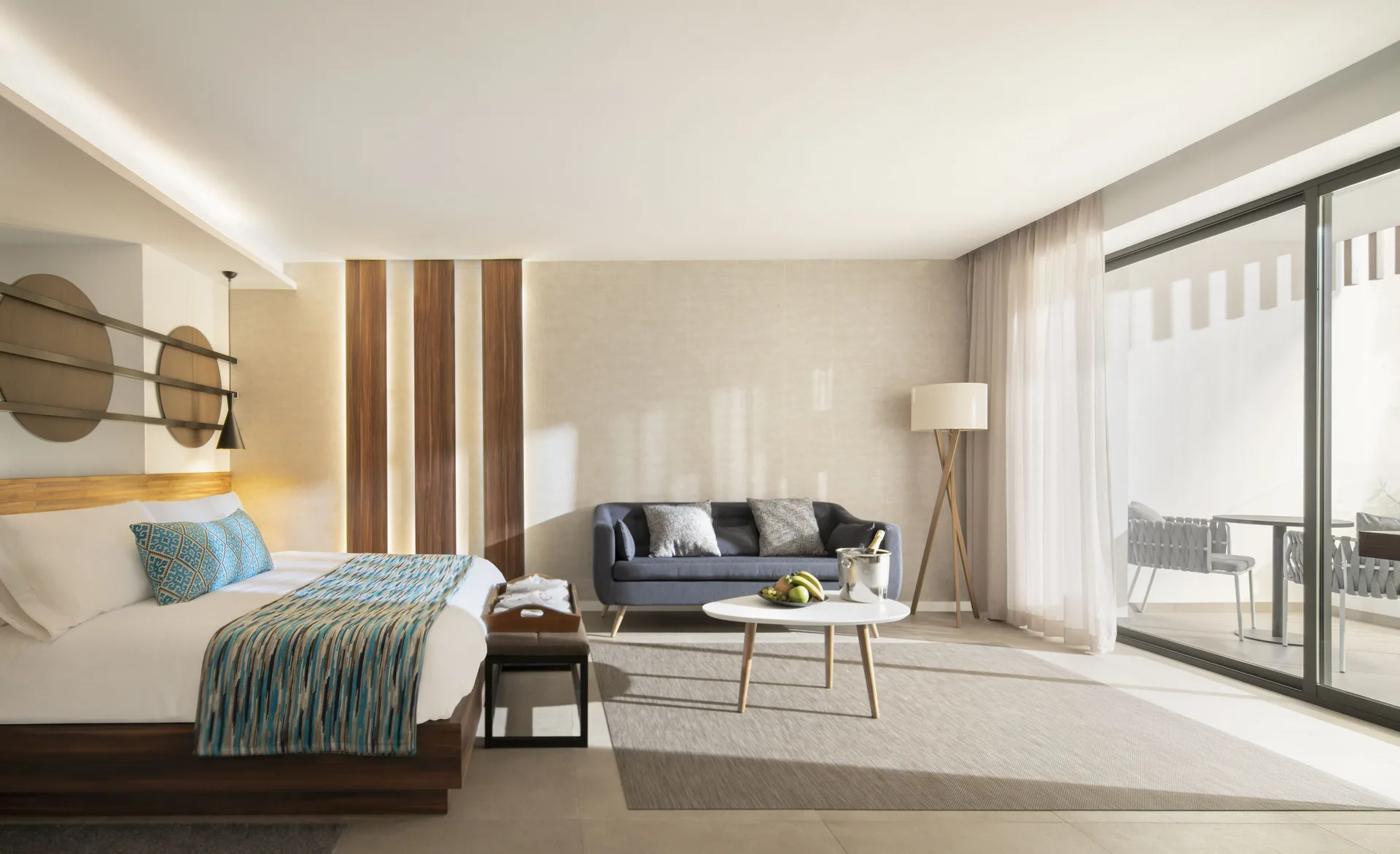 Junior Suite bedroom and sitting area at Majestic Elegance Costa Mujeres with balcony doors.