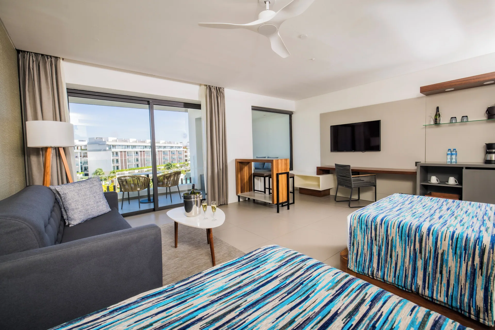 Junior Suite with two beds at Majestic Elegance Costa Mujeres, sofa, desk, minibar, and balcony.