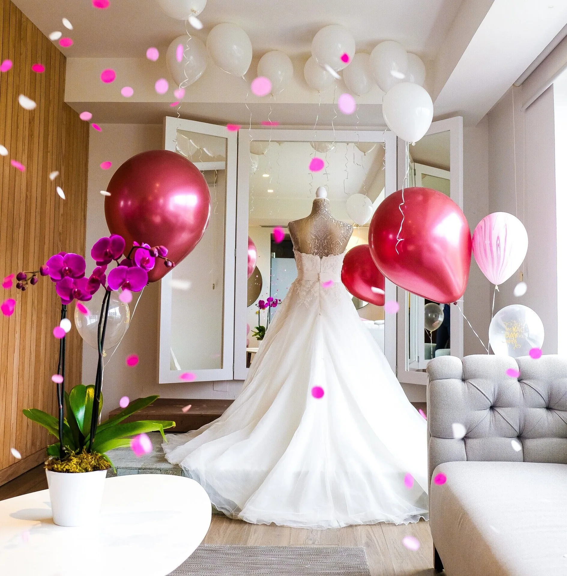 Wedding dress display with balloons and flower petals at Majestic Elegance Costa Mujeres.