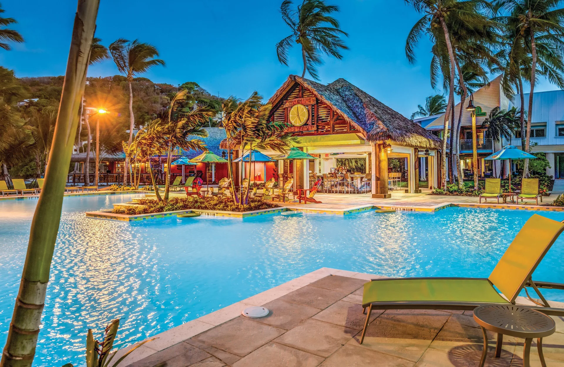 Evening pool scene with thatched bar at Margaritaville Vacation Club - St. Thomas.