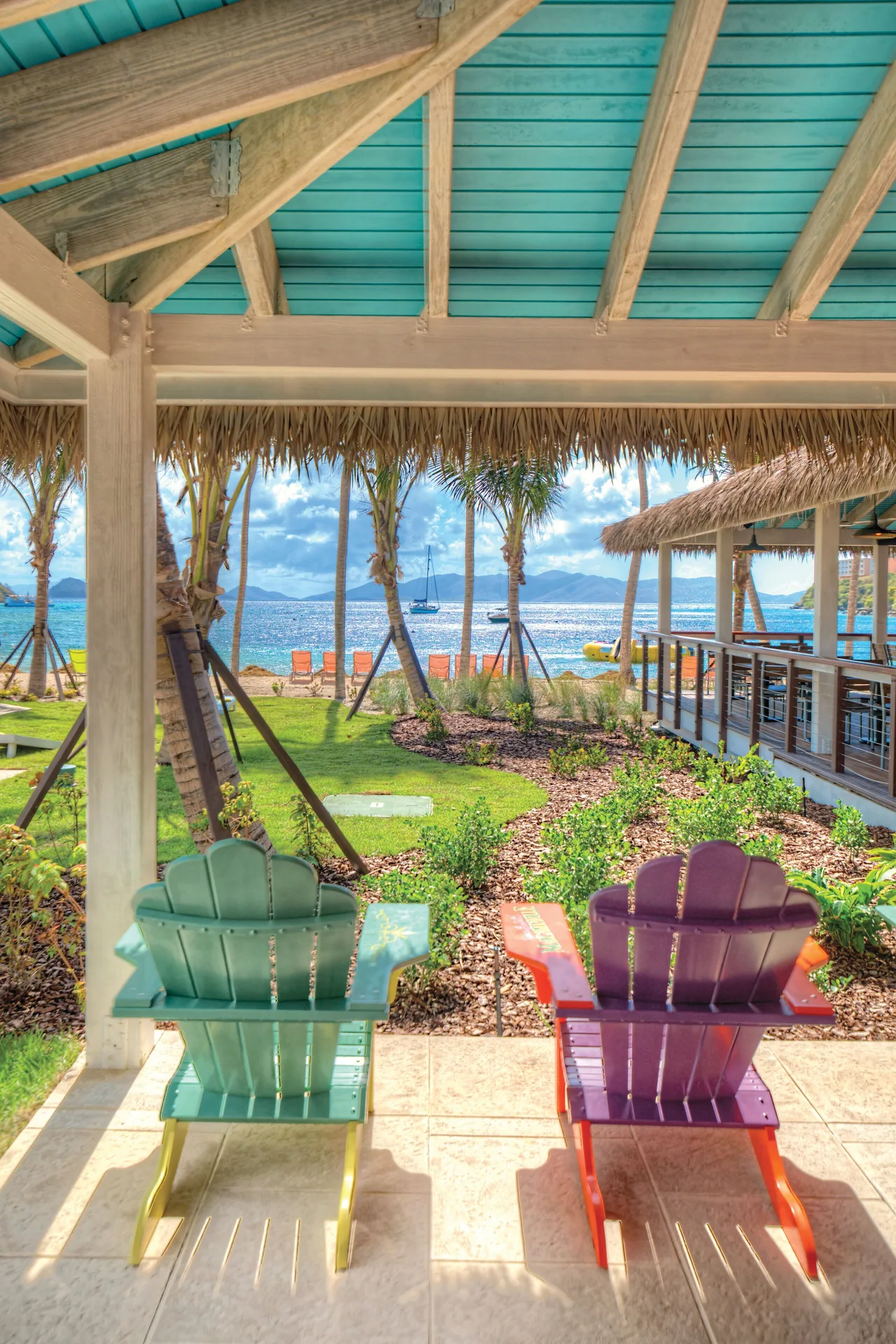 Colorful chairs face the bay from a shaded patio at Margaritaville Vacation Club - St. Thomas.