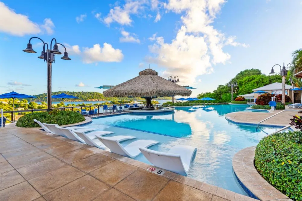 Studio Plus pool view at Margaritaville Vacation Club - St. Thomas with loungers and a thatched swim-up bar.