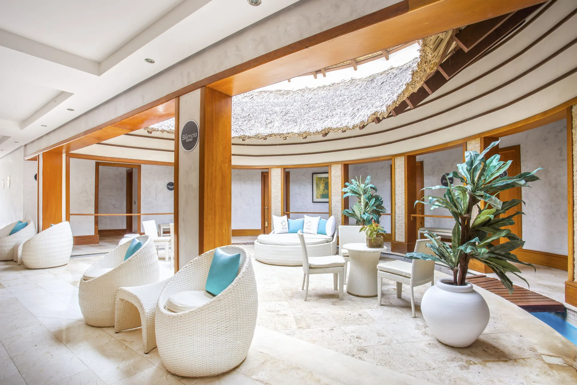 Covered spa lounge with white wicker seating and potted plants at Marien Puerto Plata.