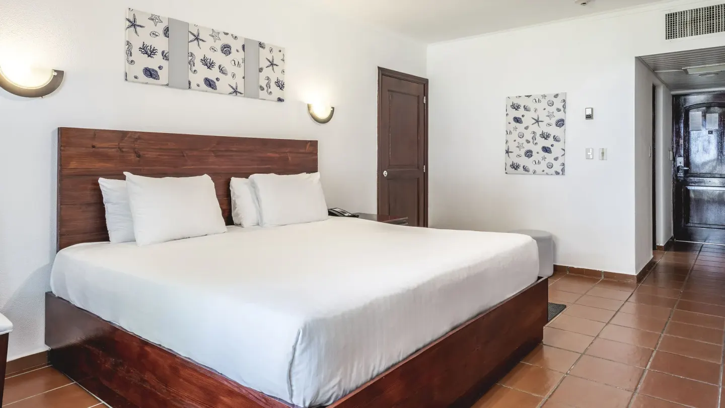 Deluxe Ocean View king room with hallway, tiled floor, and shell artwork at Marien Puerto Plata.