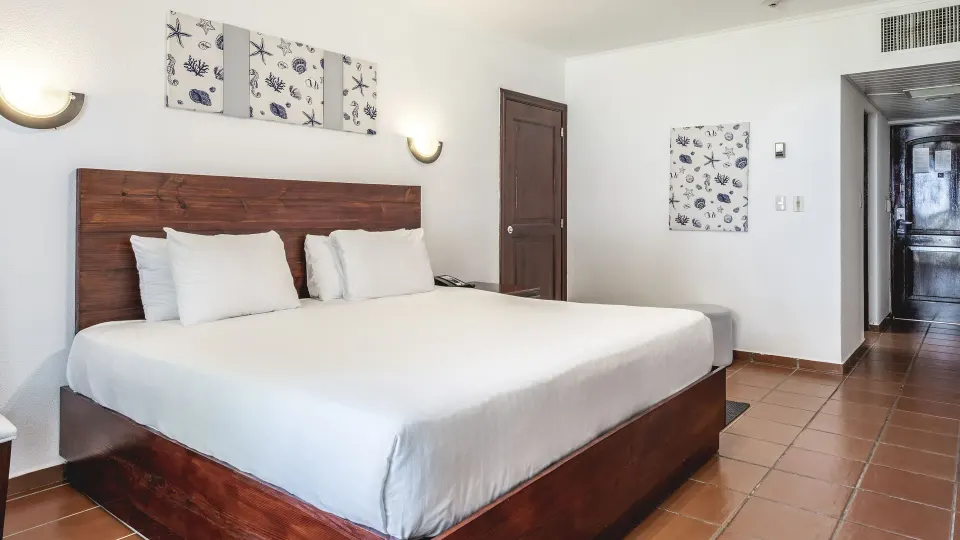 Deluxe Ocean View king room with hallway, tiled floor, and shell artwork at Marien Puerto Plata.
