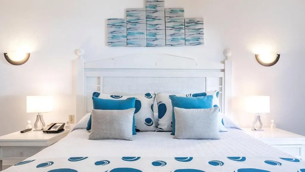 Close view of a king bed with blue accents and bedside lamps at Marien Puerto Plata.