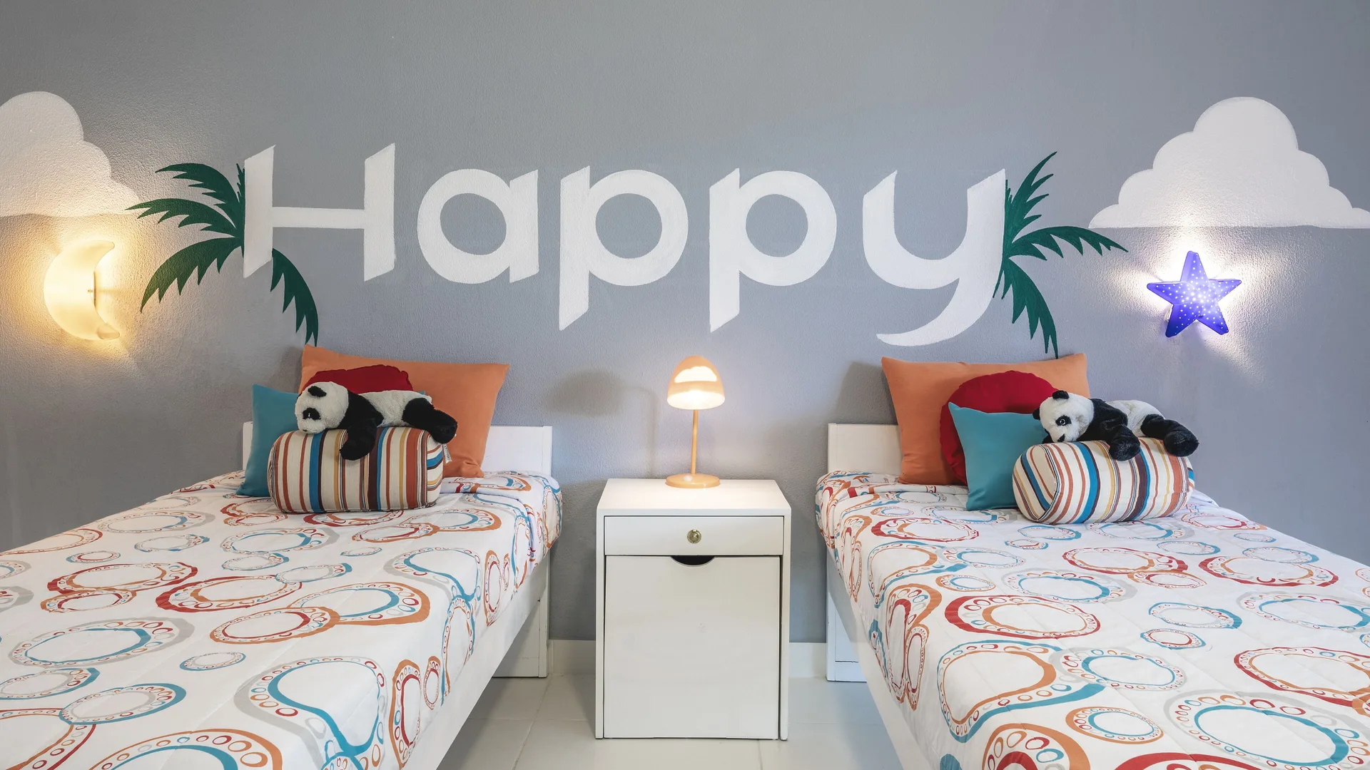 Kids' bedroom with two twin beds, panda toys, and a Happy wall mural at Marien Puerto Plata.