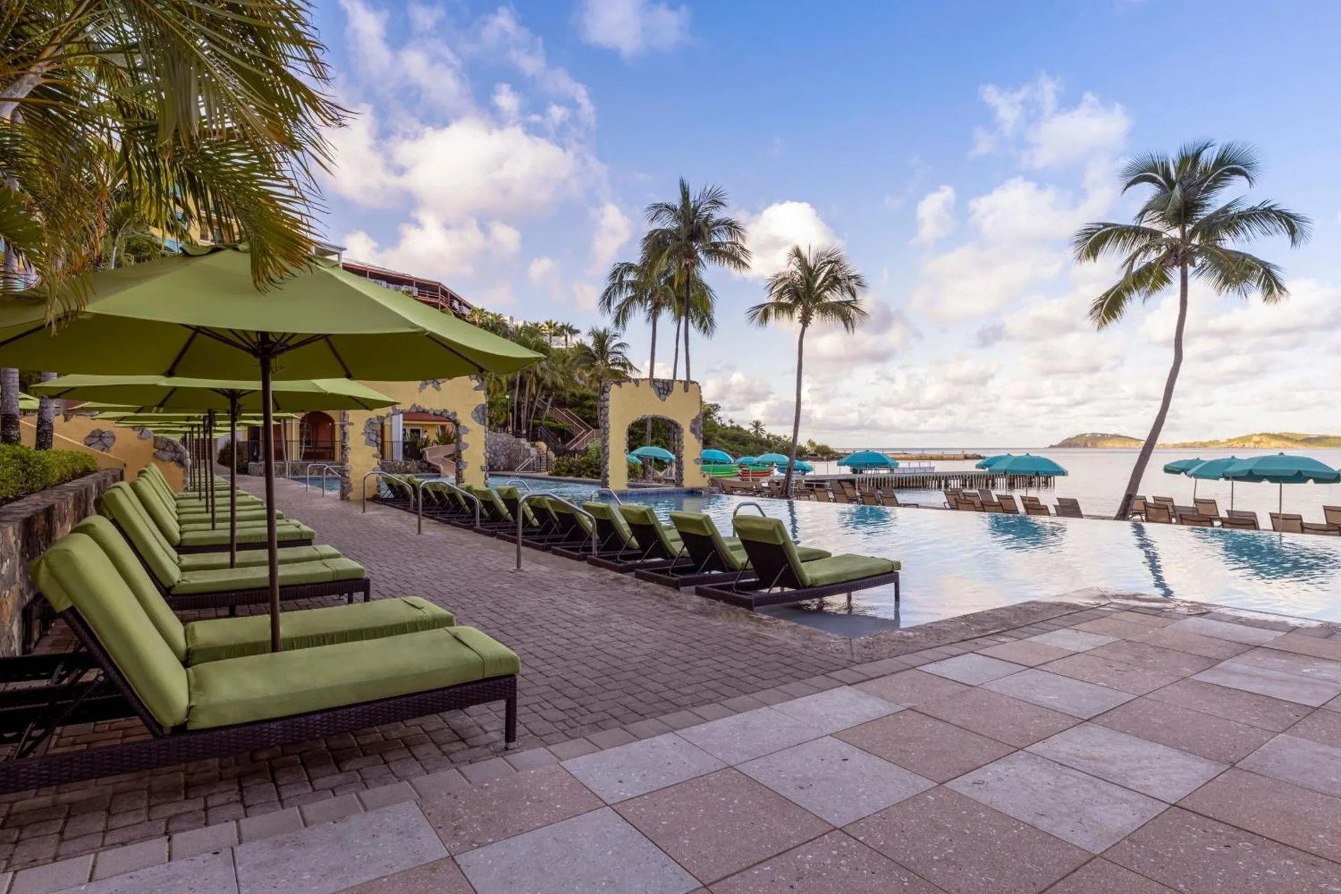 Pool deck with green loungers and bay views at Marriott's Frenchman's Cove.