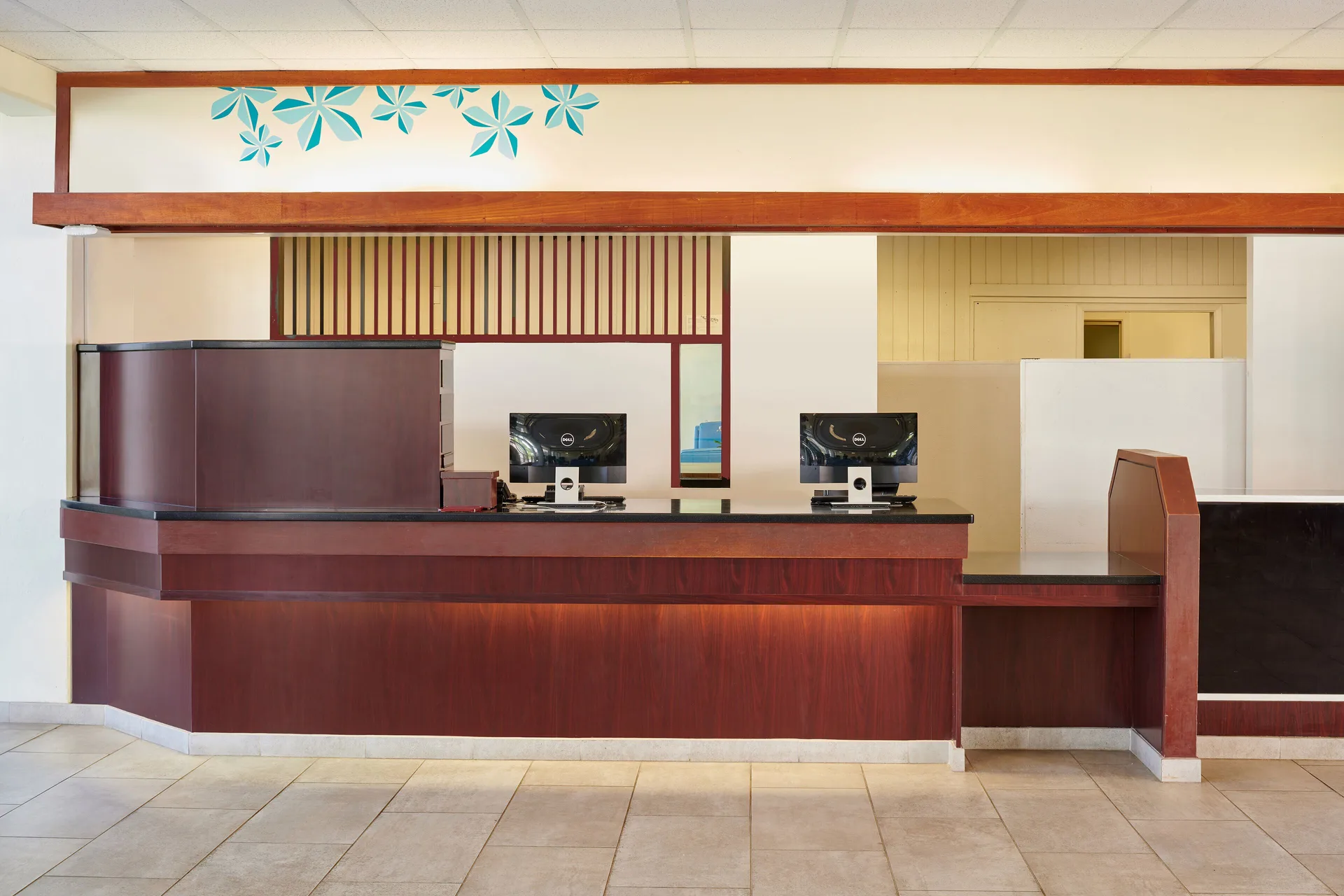 Front desk with wood counters and computer stations at Maui Beach Hotel.