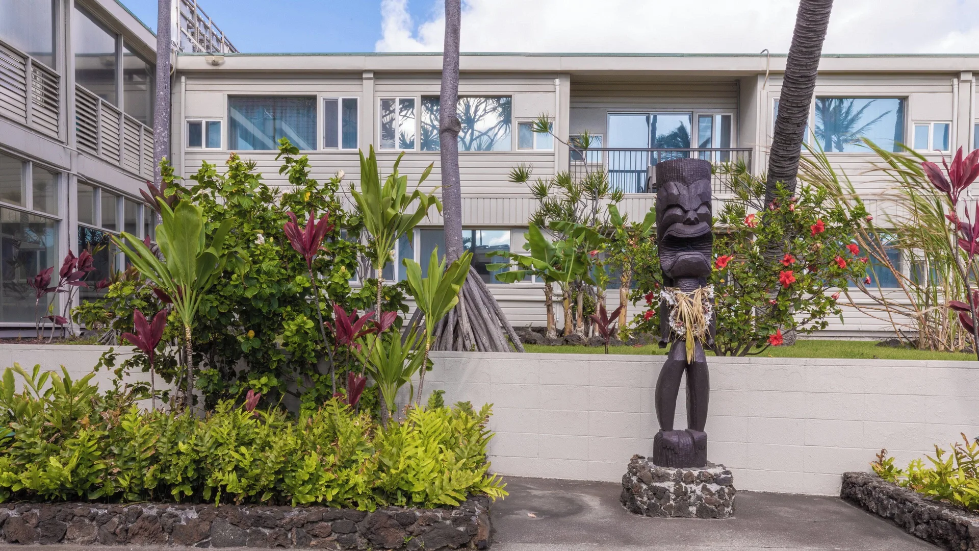 Tiki statue and tropical landscaping in a courtyard at Maui Beach Hotel.
