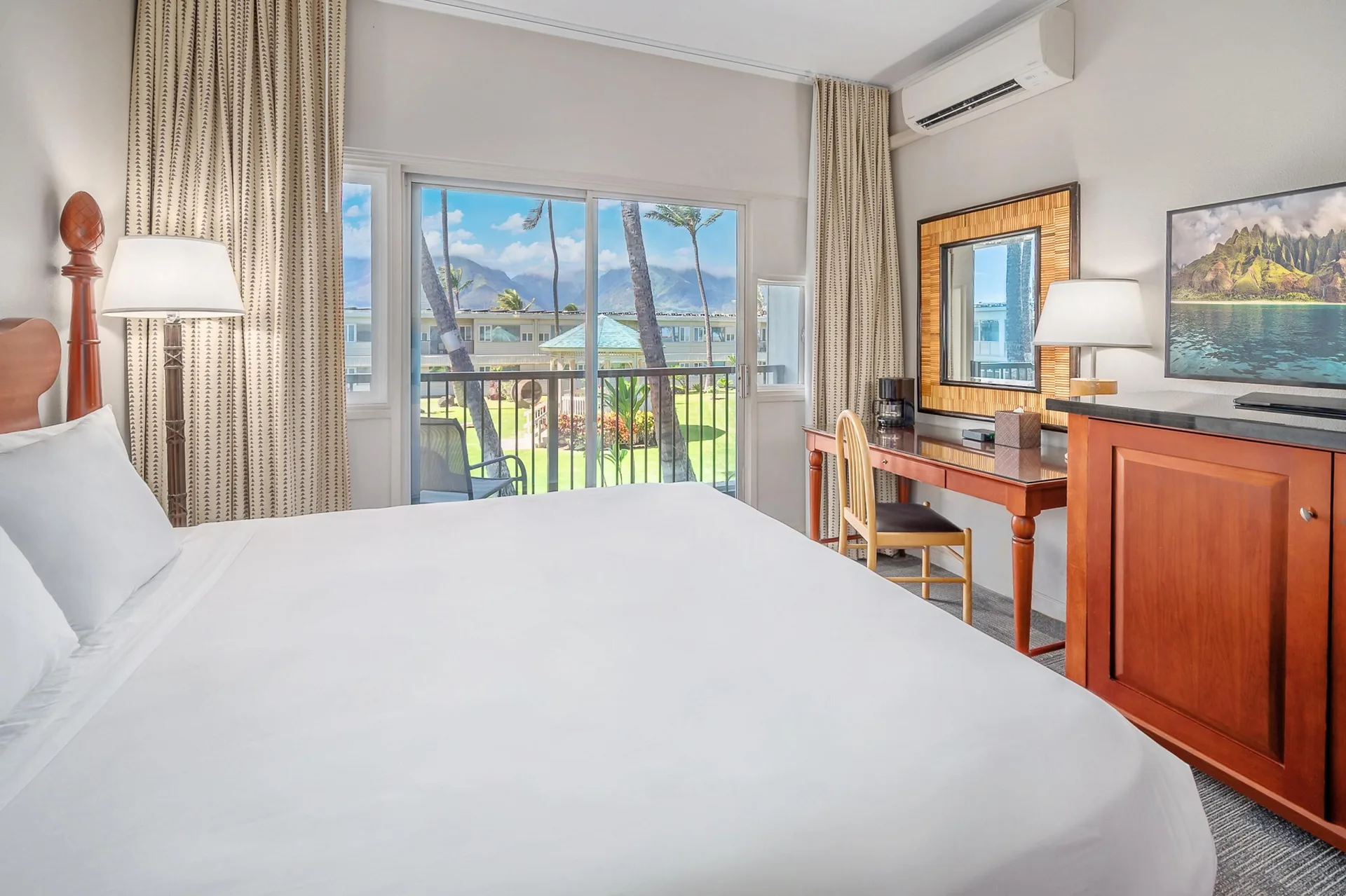 Garden View One room at Maui Beach Hotel with king bed, desk, TV cabinet, balcony, and garden view.