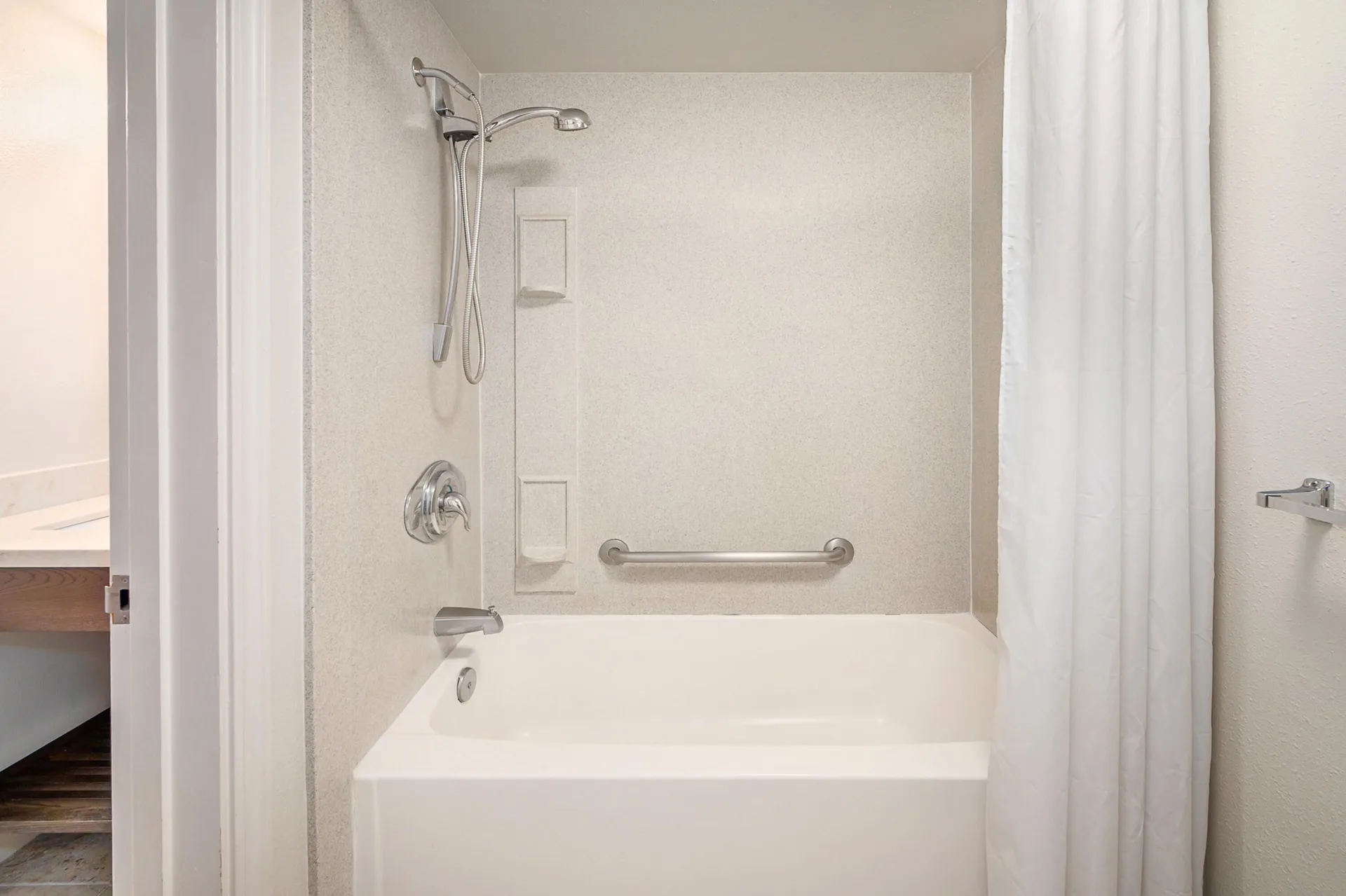 Standard Room bathroom tub and shower with grab bar at Maui Beach Hotel.