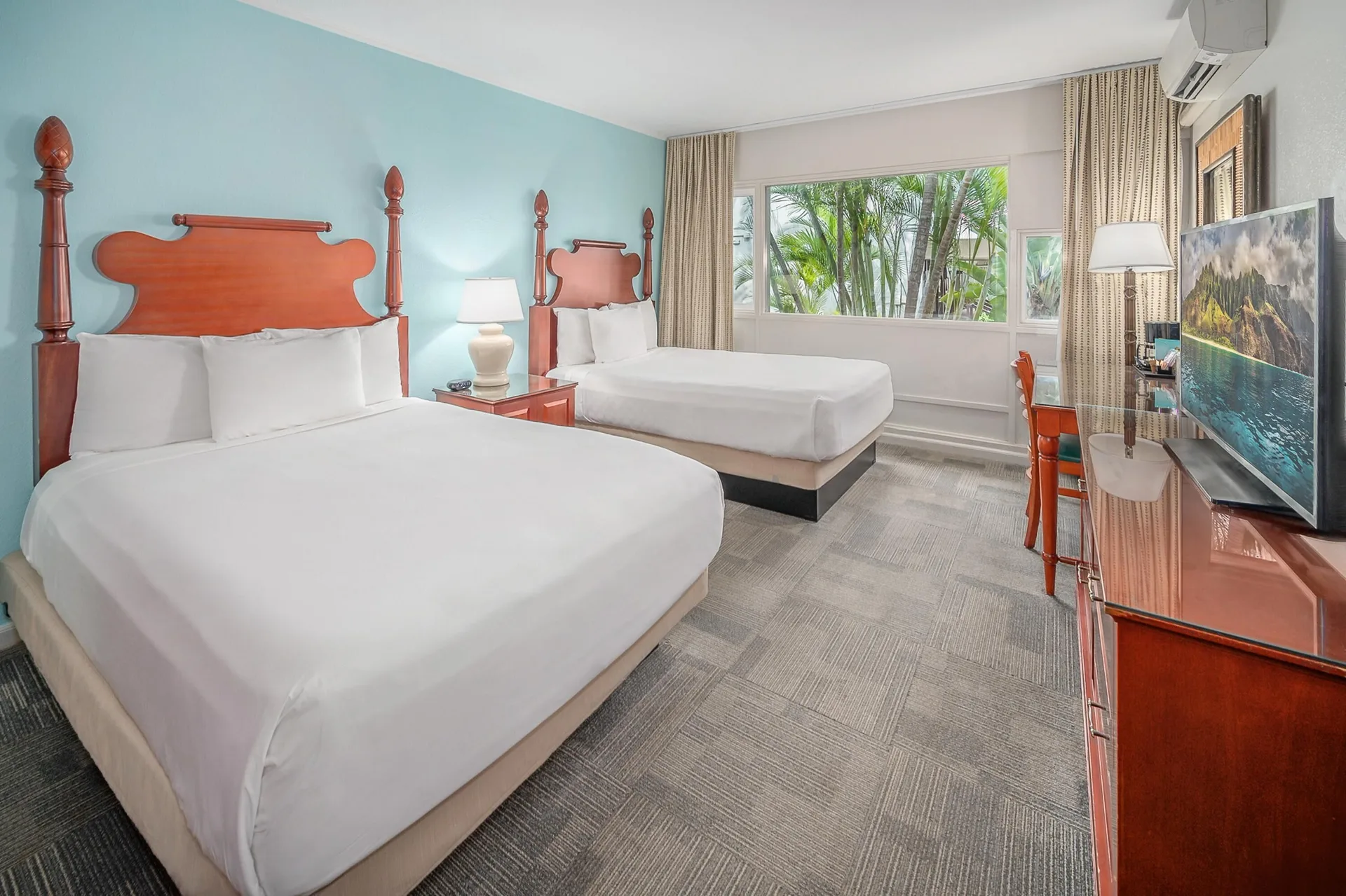 Standard Room with two beds, desk, TV, and palm-facing window at Maui Beach Hotel.