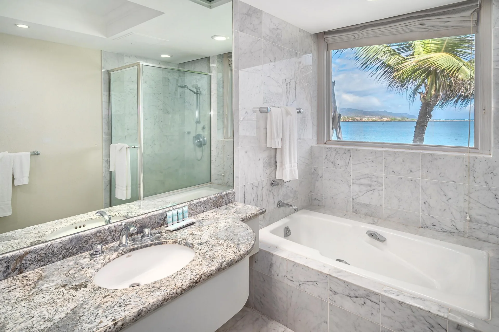 Oceanfront suite bathroom with tub, shower, and water view at Maui Beach Hotel.