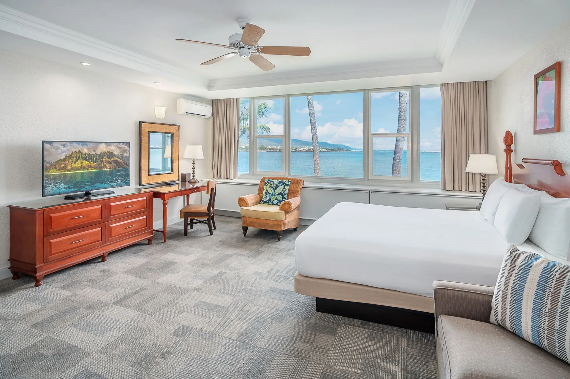 Oceanfront suite with king bed and bay windows at Maui Beach Hotel.