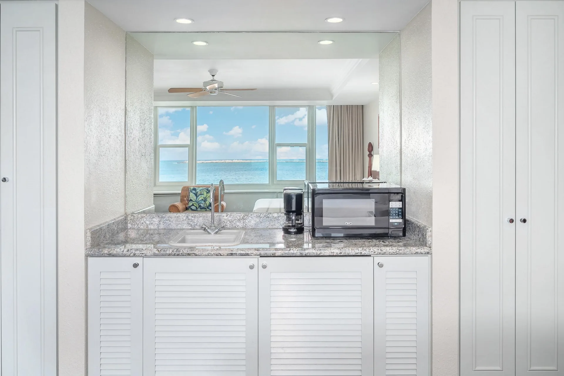 Oceanfront suite wet bar with sink, microwave, coffeemaker, and ocean view at Maui Beach Hotel.