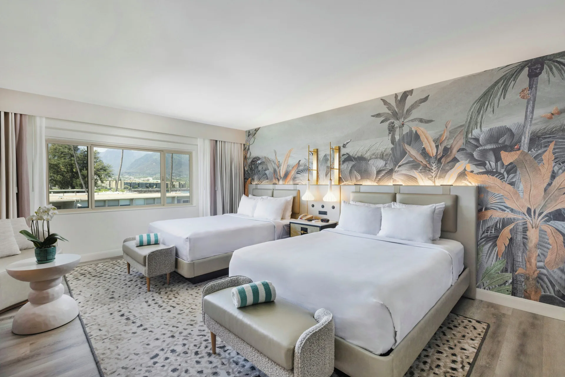 Two-bed island view room with mural and large window at Maui Seaside Hotel.