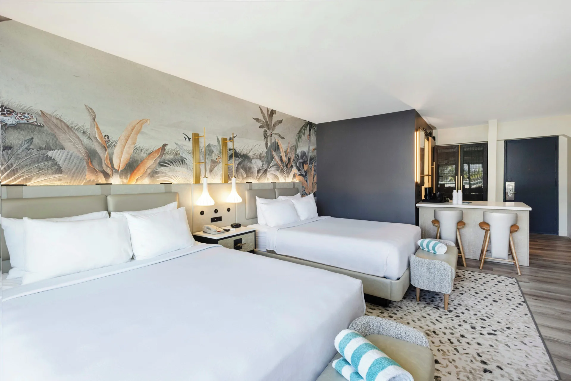 Renovated Tower guest room with two beds and tropical mural at Maui Seaside Hotel.