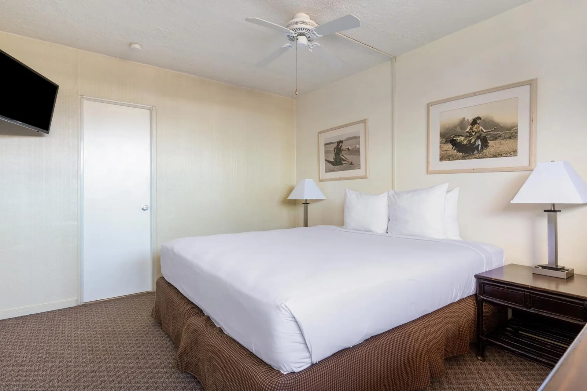 Standard One guest room with one bed, wall-mounted TV and bedside lamps at Maui Seaside Hotel.