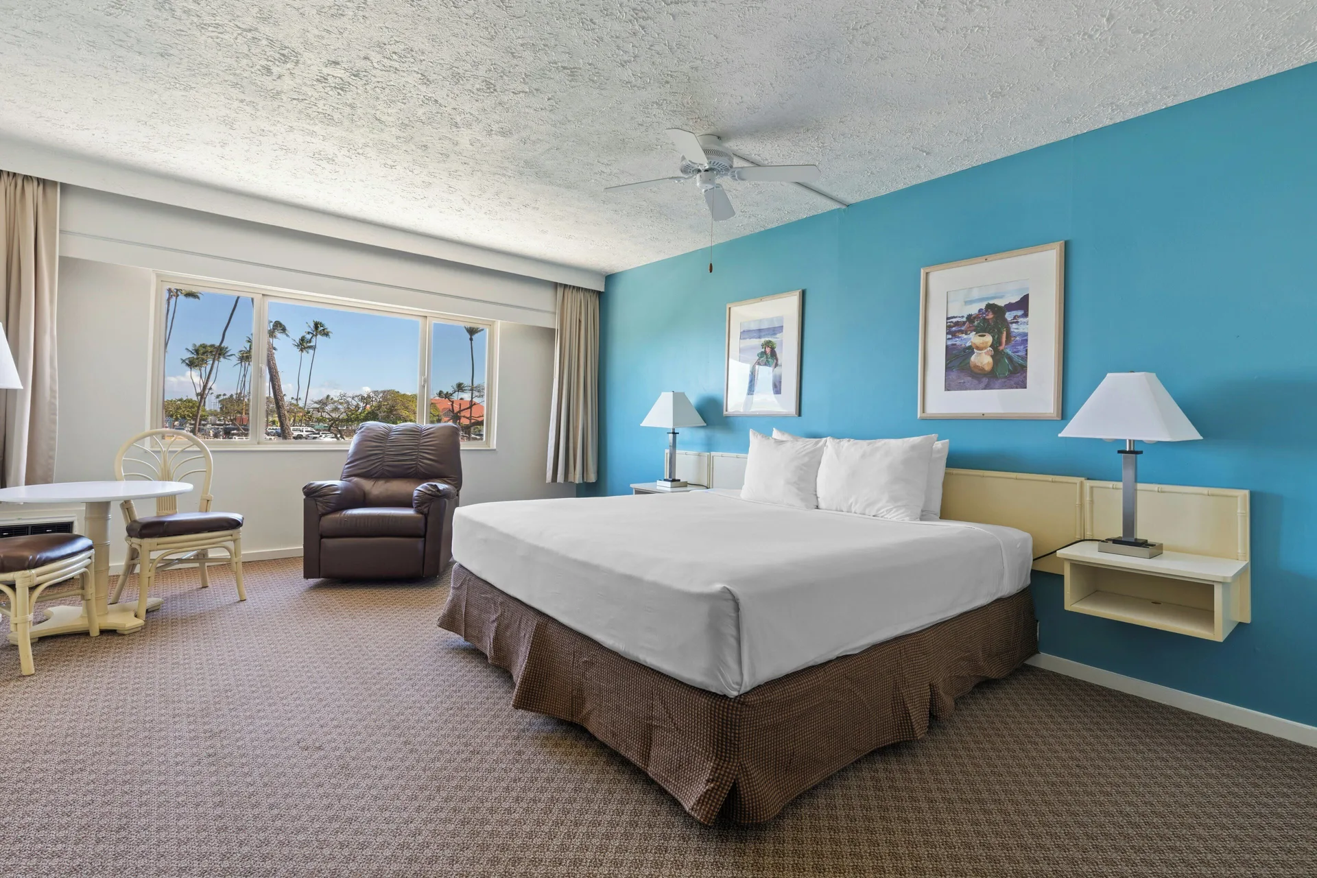 Standard Room with king bed, armchair and window seating area at Maui Seaside Hotel.
