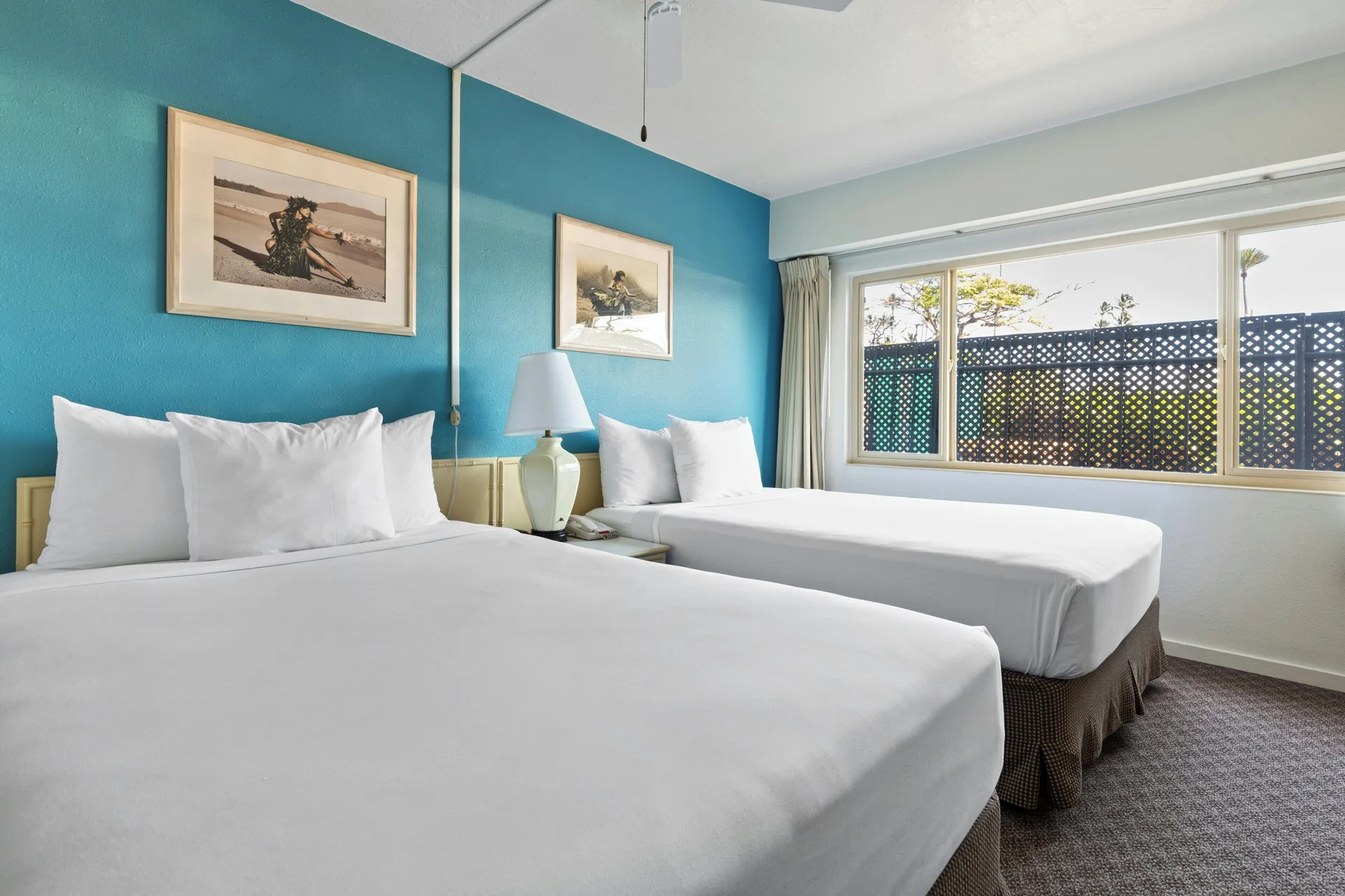 Standard Room with two beds and a wide window with lattice outside at Maui Seaside Hotel.