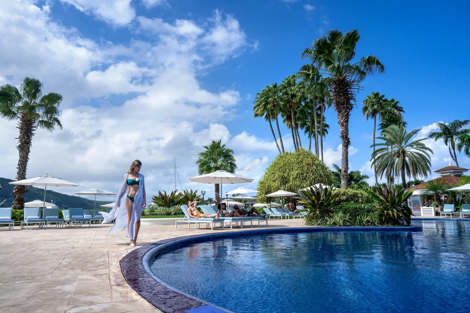 Pool deck with loungers, umbrellas, and palms at Moon Palace Jamaica.